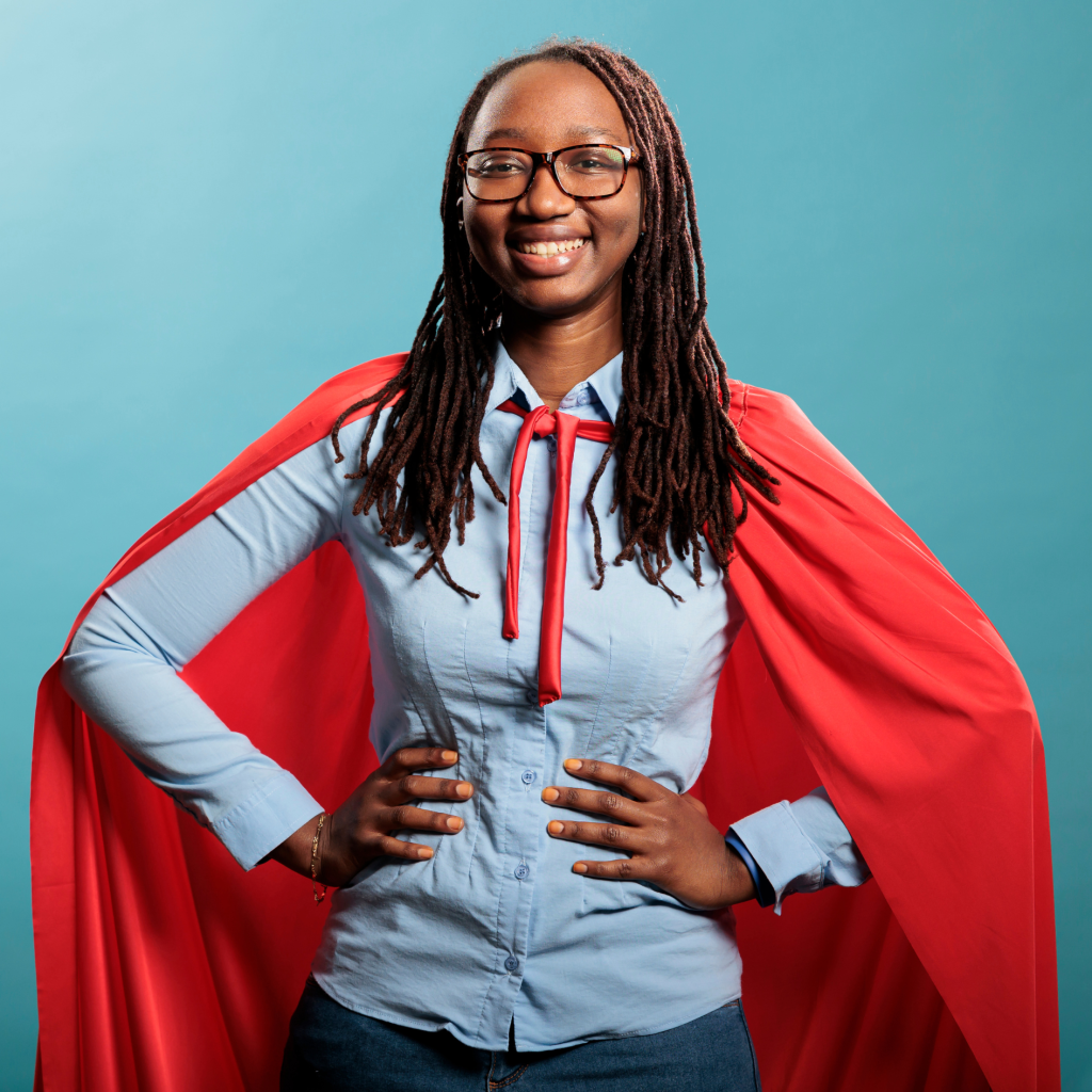 Proud superhero woman with superpower abilities wearing mighty hero cloak while smiling confident at camera.